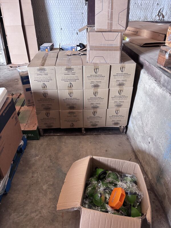 Stack of brown shipping boxes and a box of green-wrapped parts